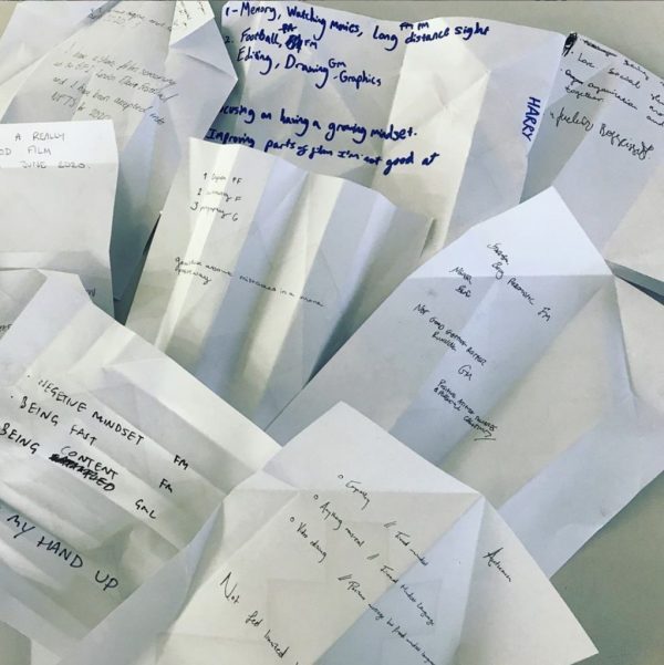 Unfolded pieces of white paper with students' handwritten notes